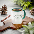 White mug with green interior and handle on a wooden board with decorative elements