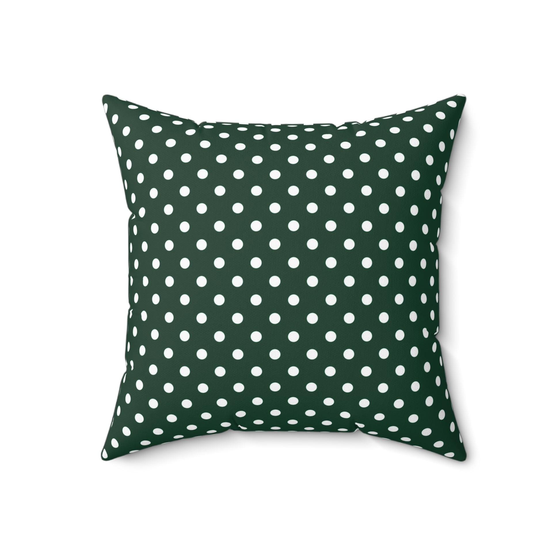 Green pillow with white polka dots on a white background