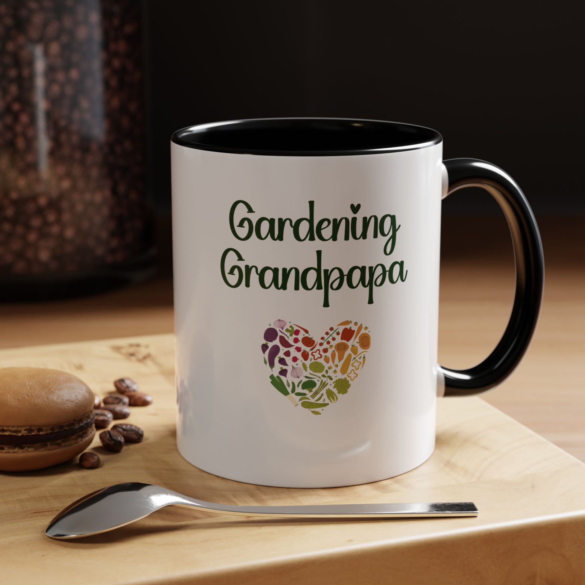 White mug with 'Gardening Grandpapa' text and heart design on a wooden surface with coffee beans and a spoon.