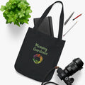 Black tote bag with 'Mommy Gardener' text and floral design on a white surface with stationery items.