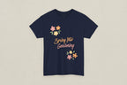 Black t-shirt with 'Spring Into Gardening' text and floral designs on a white background