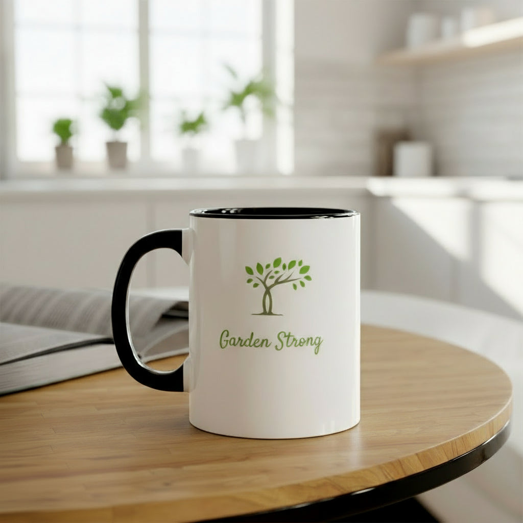 White mug with black handle featuring 'Garden Strong' text and tree design on a wooden table.