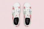 White sneakers with floral patterns on a beige background