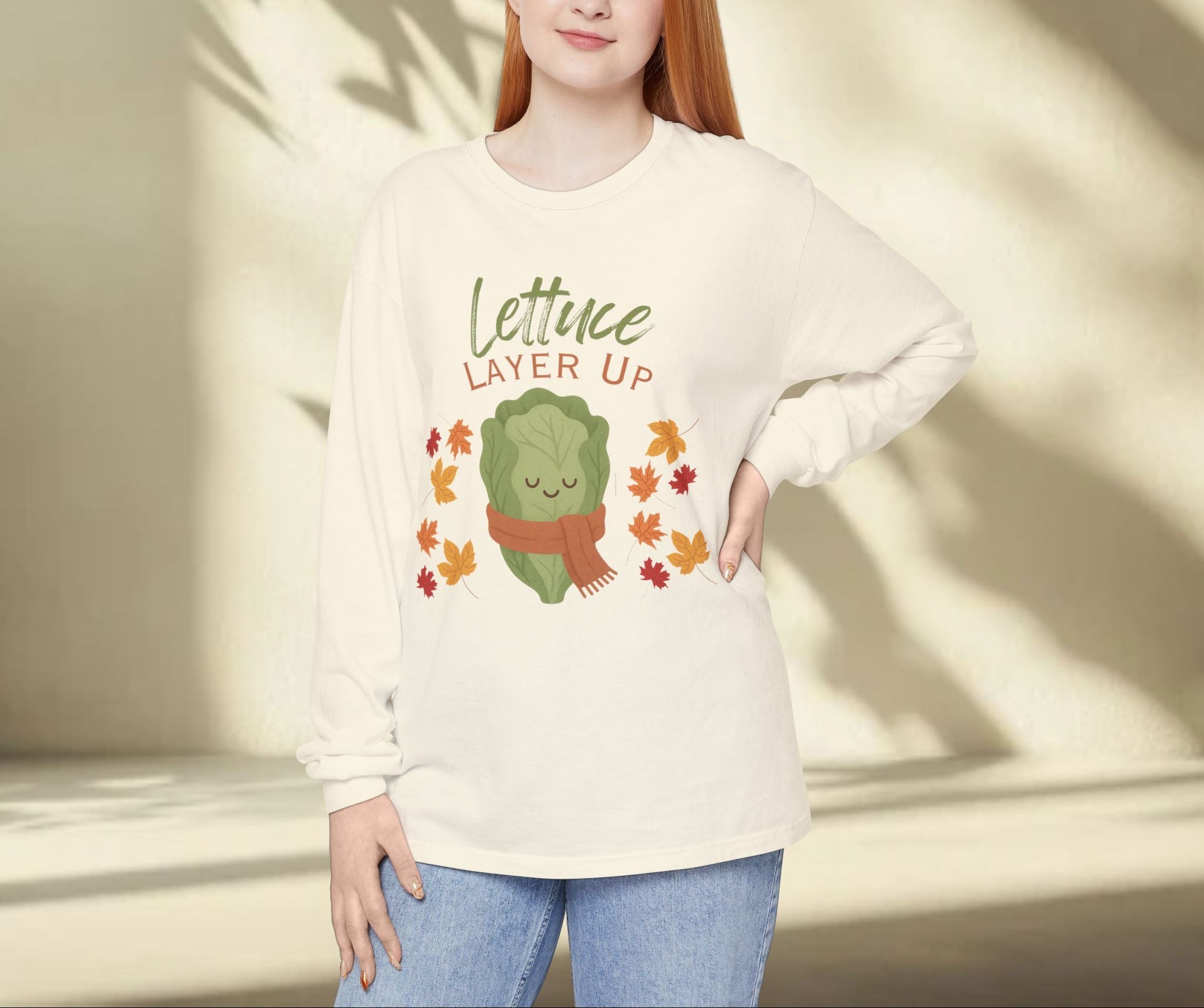 Person wearing a cream sweatshirt with a lettuce graphic and text in a sunlit room.