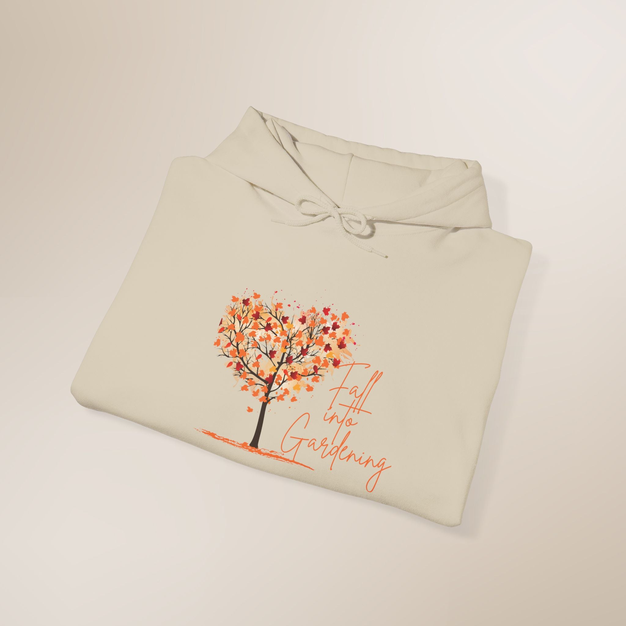 Folded beige hoodie with a tree and 'Fall into Gardening' text on a light background