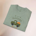 Folded light green t-shirt with a graphic of a truck and 'GARDEN' text on a beige background
