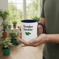 Person holding a mug with 'Grandpa Gardener' text in a room with plants