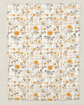 Floral patterned fabric with orange and white flowers on a beige background
