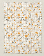 Floral patterned fabric with orange and white flowers on a beige background