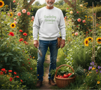 Man in a garden wearing a 'Gardening Grandpa' sweatshirt with a basket of vegetables.