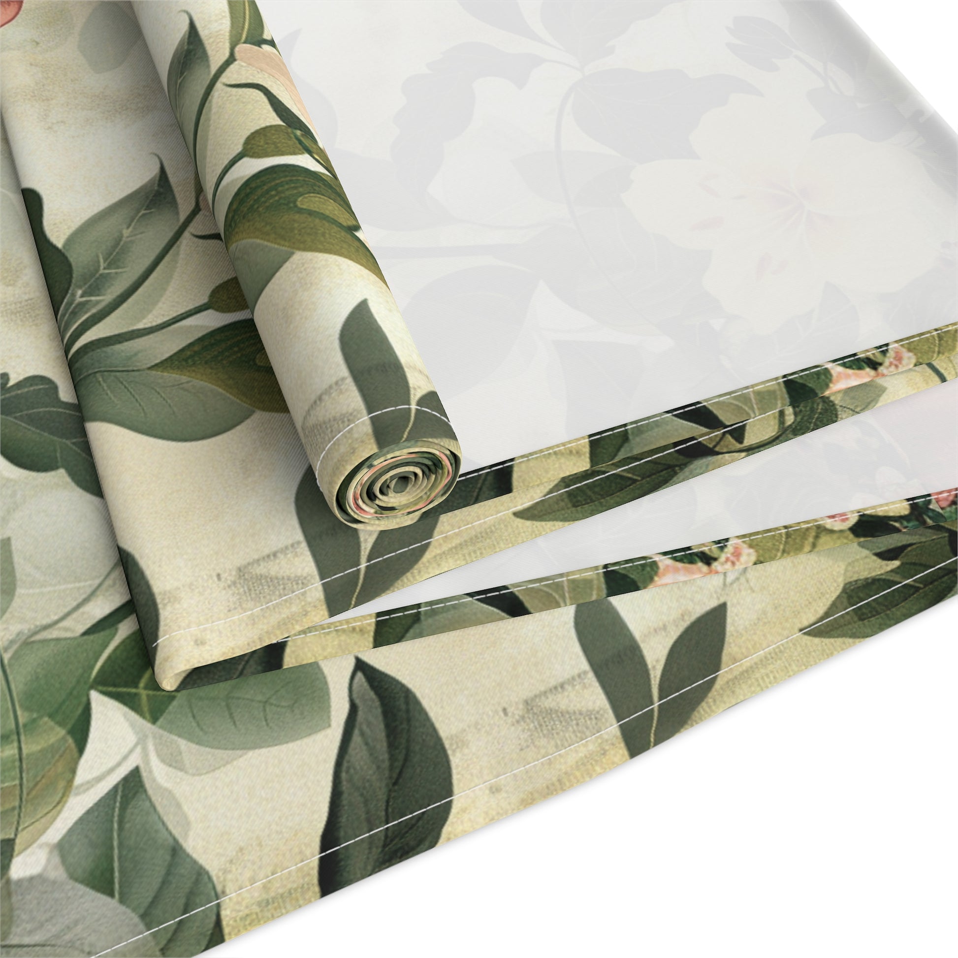 Roll of green leaf-patterned fabric on a white background
