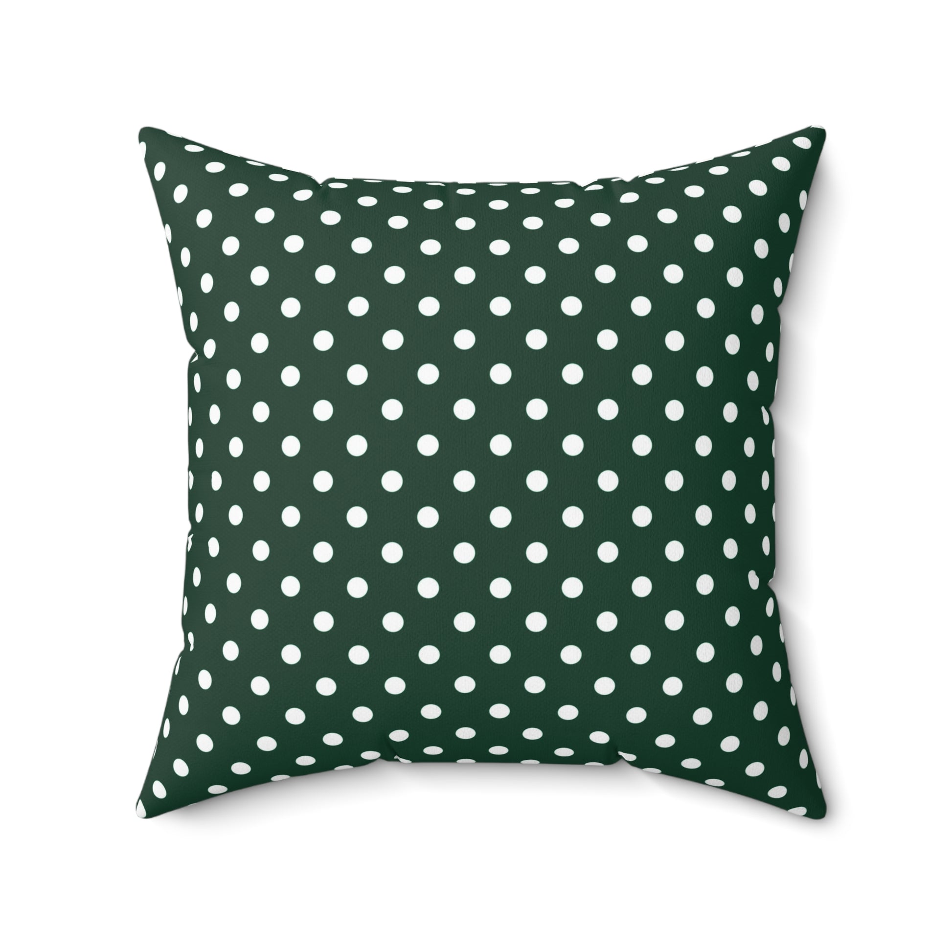 Green pillow with white polka dots on a white background