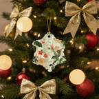 Decorative floral ornament hanging on a Christmas tree with lights and red ornaments.