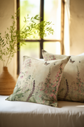 Floral-patterned pillows on a couch with a plant in the background