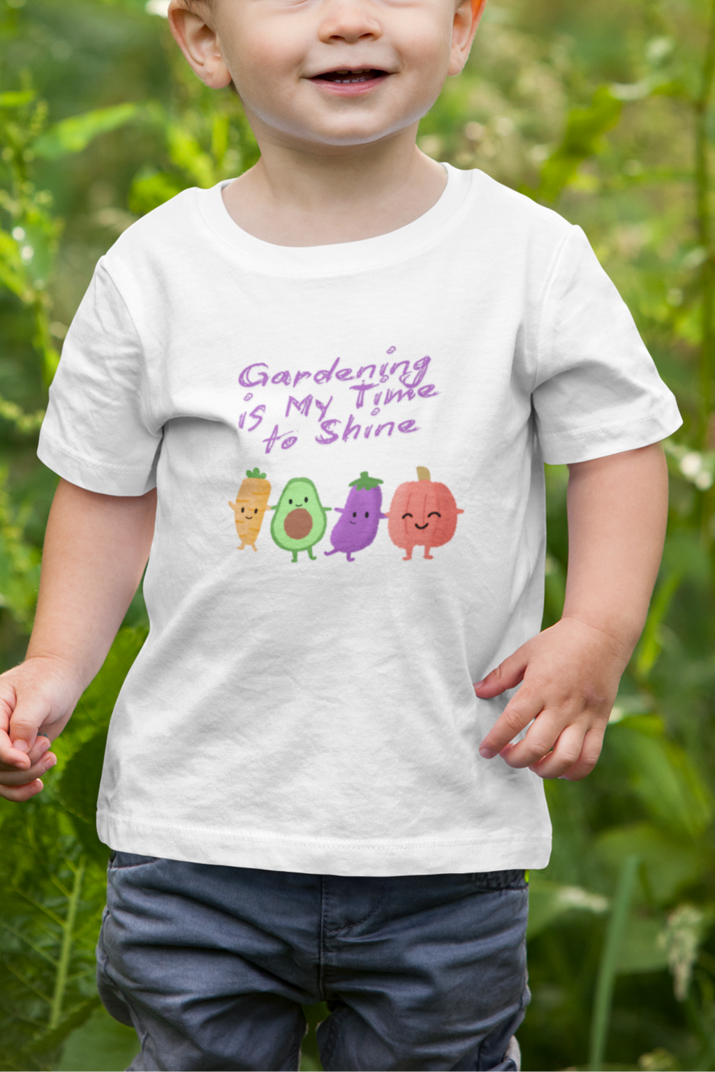 Child wearing a white t-shirt with colorful avocado graphics and text in a garden setting
