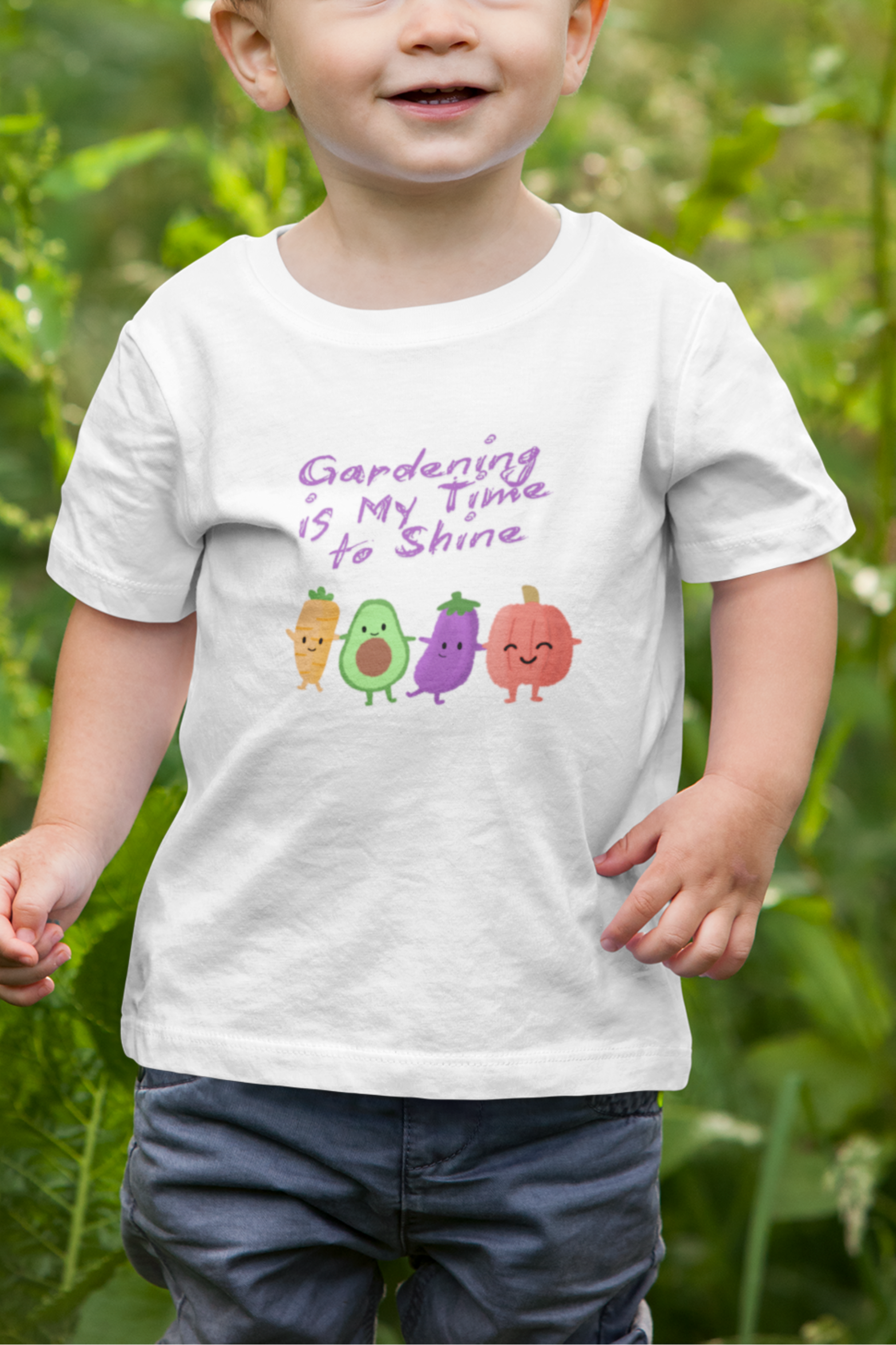 Child wearing a white t-shirt with colorful avocado graphics and text in a garden setting