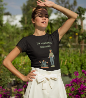 Woman wearing a black t-shirt with a graphic and text, standing in a garden.