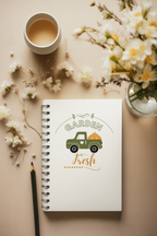 Notebook with 'Garden Fresh' design, cup of coffee, and flowers on a beige surface