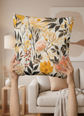 Floral-patterned pillow held up in a living room setting