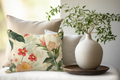 Floral pillow and decorative vase on a surface with a blurred background