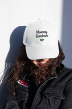 Person wearing a white cap with 'Mommy Gardener' text against a plain background