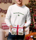 Man holding a Christmas gift in front of a decorated tree and 'Merry Christmas' banner.