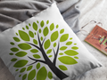 Decorative pillow with a green tree design on a gray surface