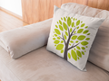 Decorative pillow with a tree design on a beige couch