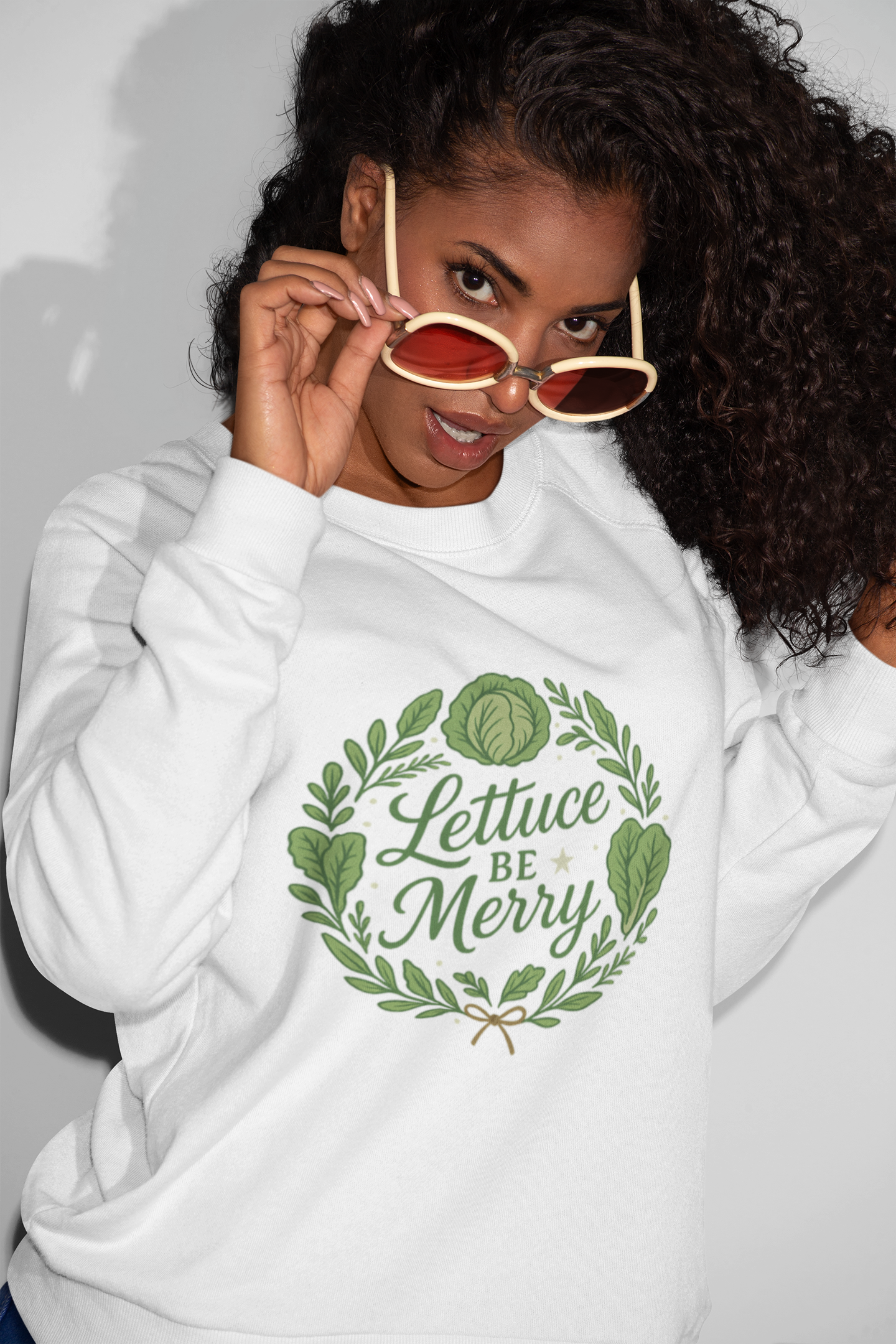 Person wearing a white hoodie with 'Lettuce Be Merry' design and sunglasses.