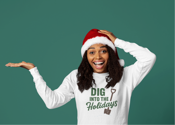 Person wearing a white sweatshirt with holiday text and a Santa hat on a green background