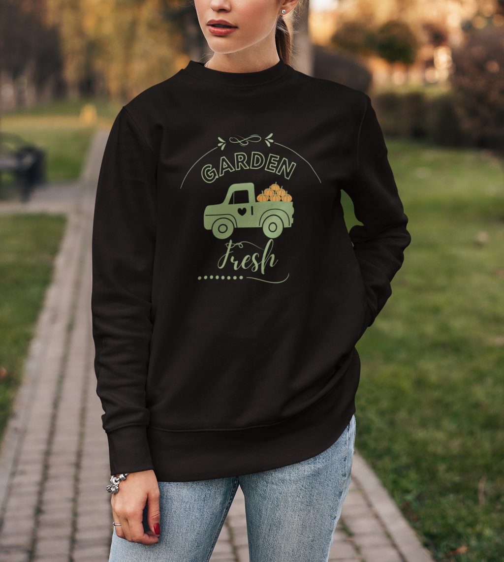Woman wearing a black sweatshirt with a graphic design in an outdoor setting