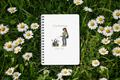 Notebook with gardening illustration on grass and daisies