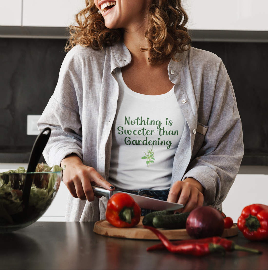 Woman in a kitchen preparing food with a 'Nothing is Sweeter than Gardening' shirt on.