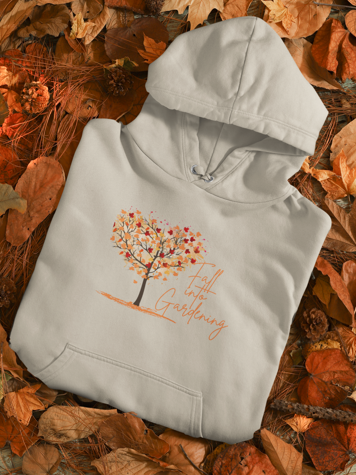 Light gray hoodie with autumn-themed design on a bed of leaves