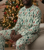 Person wearing a festive pajama set in front of a decorated Christmas tree.