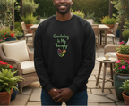 Man wearing a black sweatshirt with 'Gardening is My Therapy!' text in a garden setting