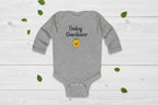 Gray baby onesie with 'Baby Gardener' text and emoji on a white background