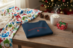 Blue sweatshirt with 'Merry Christmas' text on a wooden table with festive decor.