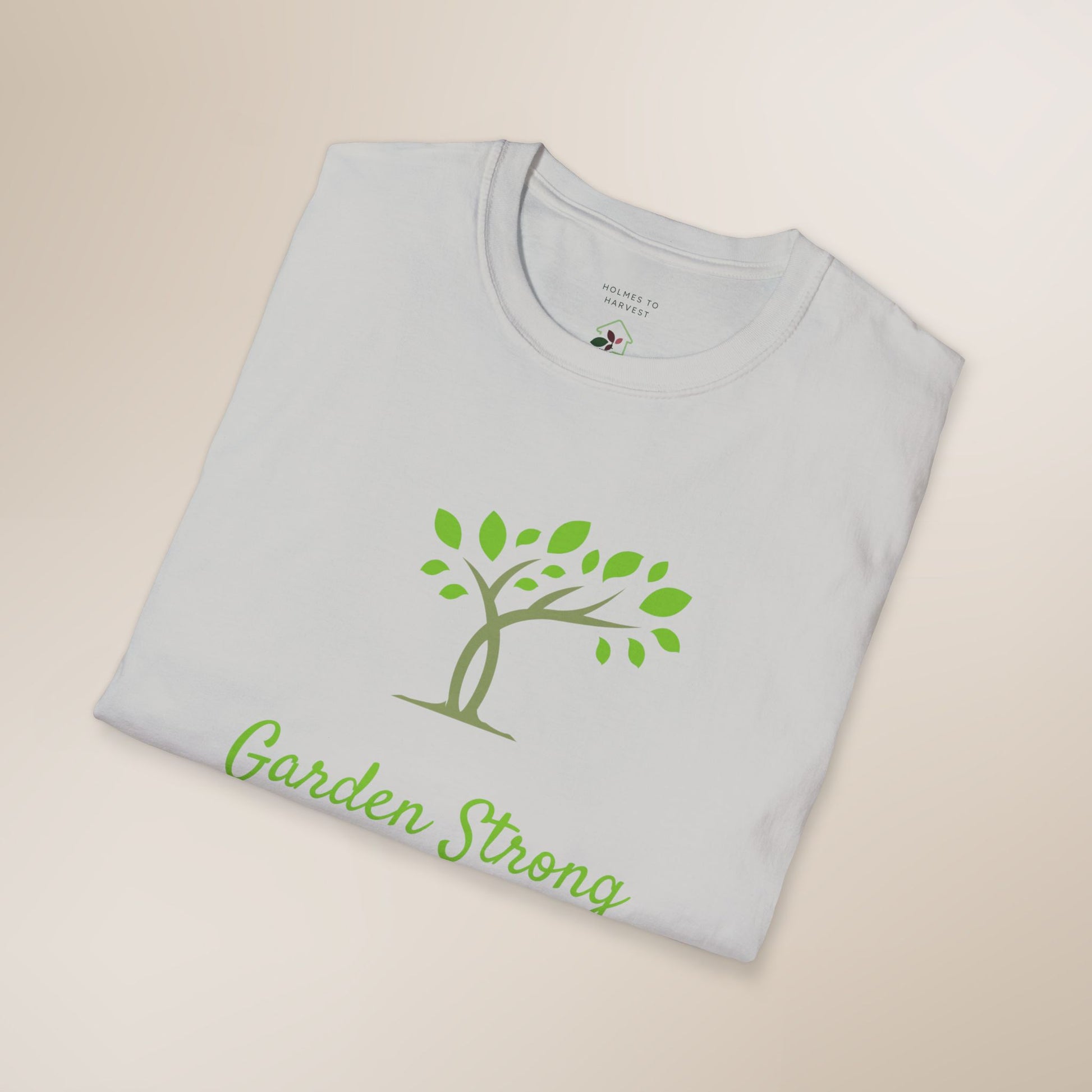 Folded gray t-shirt with green tree and 'Garden Strong' text on a beige background