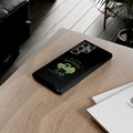 Black phone case with a green design on a wooden surface