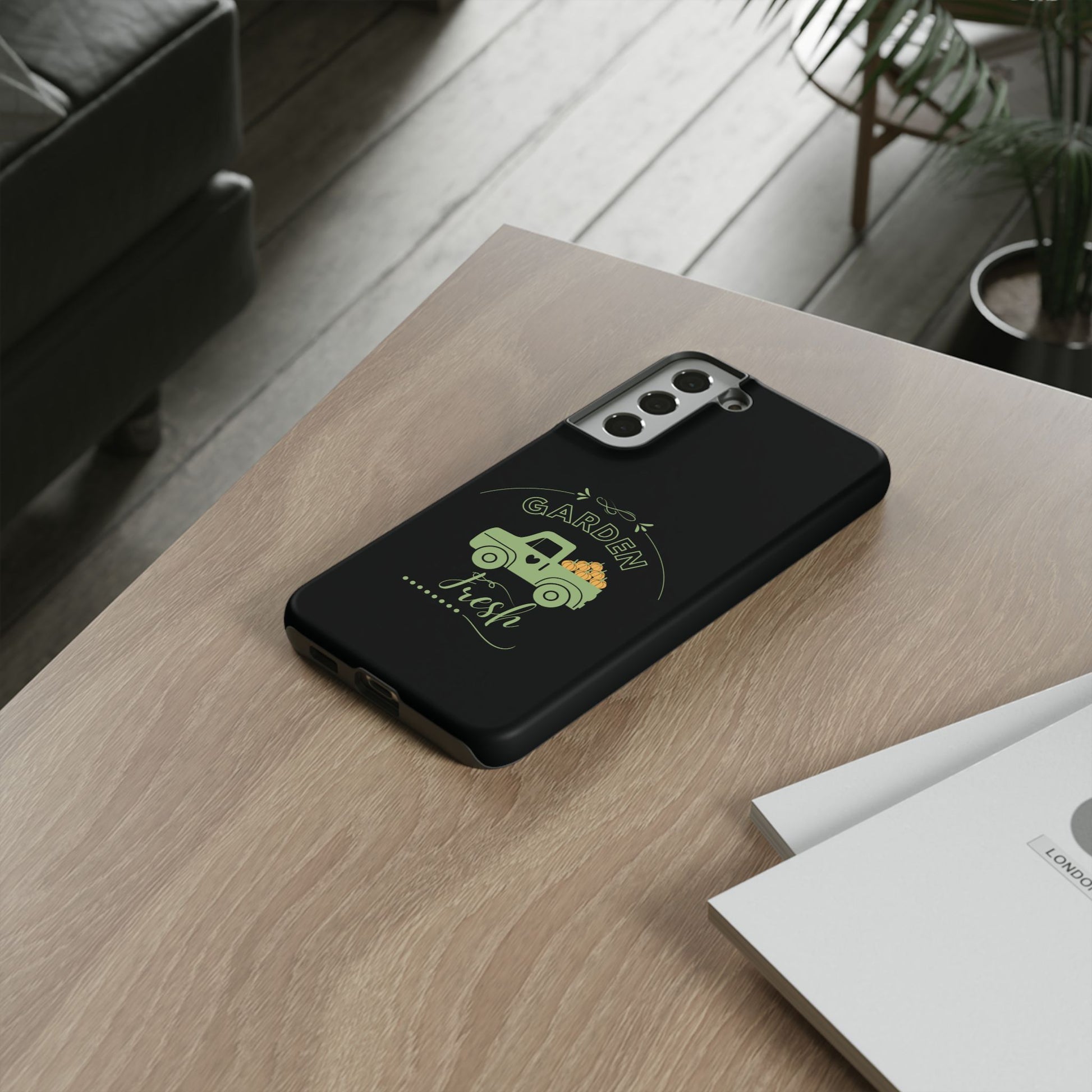 Black phone case with green design on a wooden surface