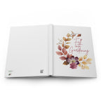 Open book with floral design and text on a white background