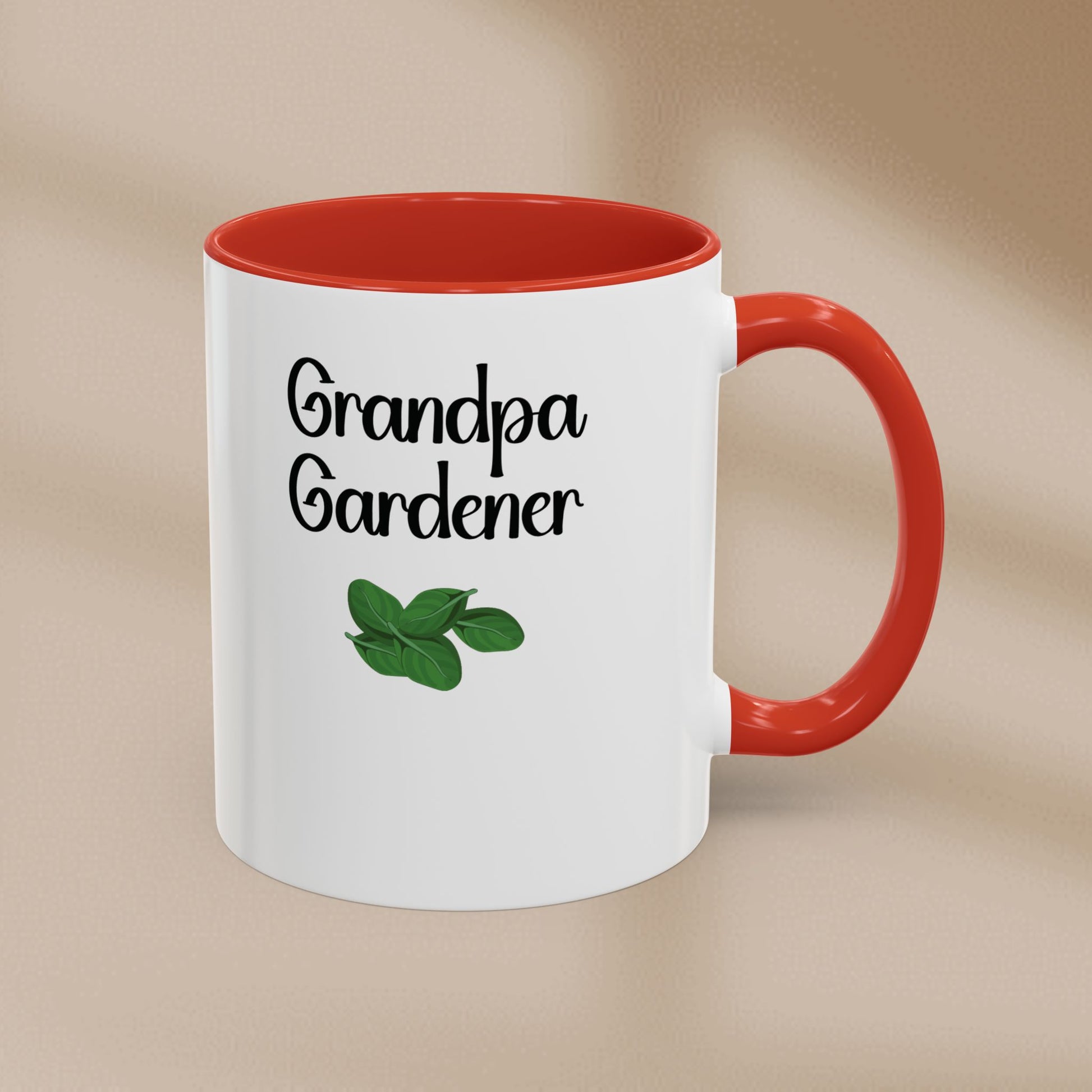 White mug with red interior and handle, featuring 'Grandpa Gardener' text and a leaf graphic on a beige background.