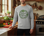 Person wearing a gray sweatshirt with a green graphic in a kitchen