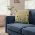 Decorative pillow with floral and butterfly pattern on a blue sofa in a living room.
