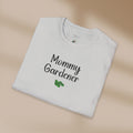 Folded white t-shirt with 'Mommy Gardener' text on a beige background