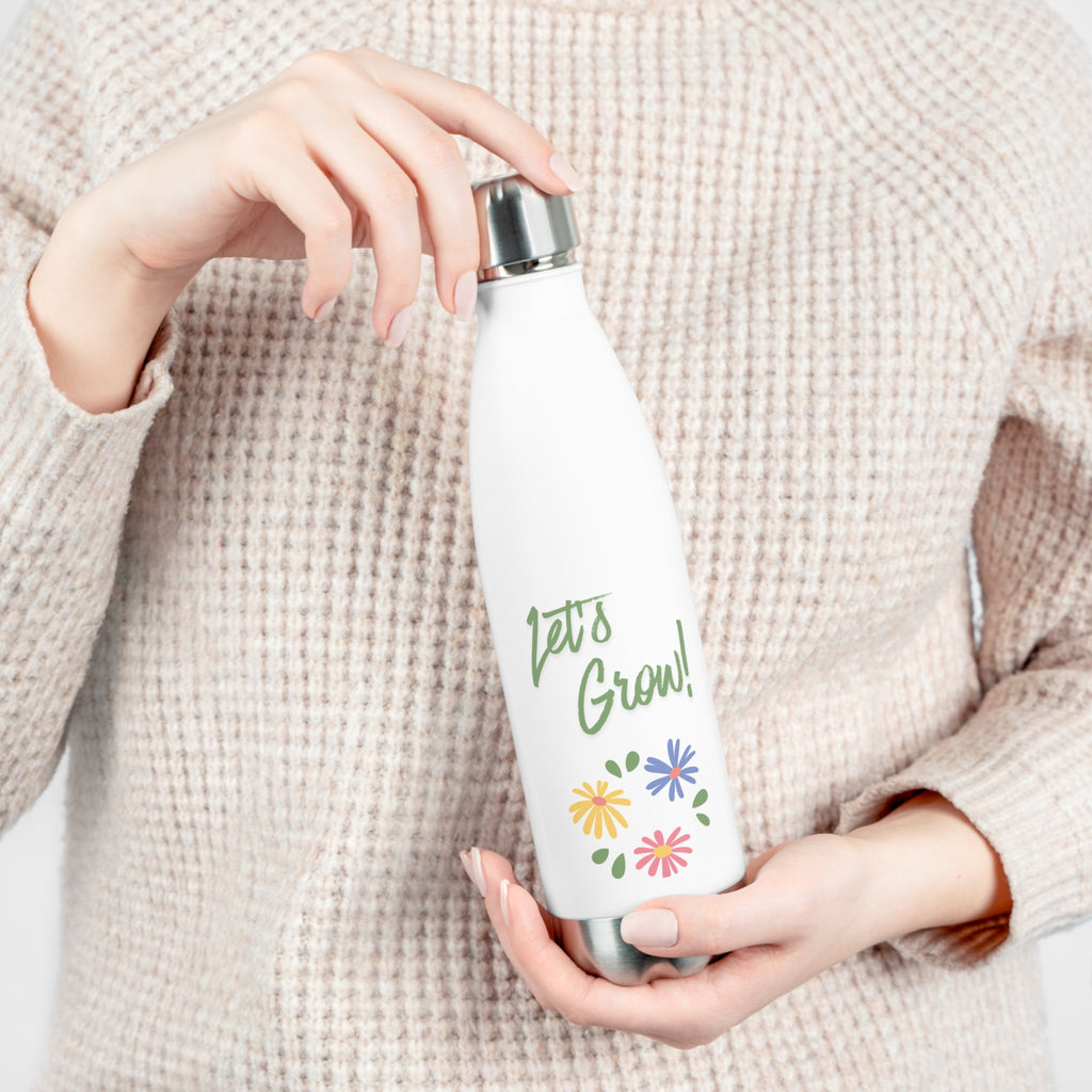 Person holding a white water bottle with 'Let's Grow!' text and floral designs.
