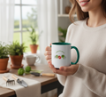 Person holding a mug with a garden-themed design in a home setting