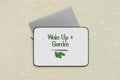 Laptop sleeve with 'Wake Up & Garden' text and leaf graphic on a white background