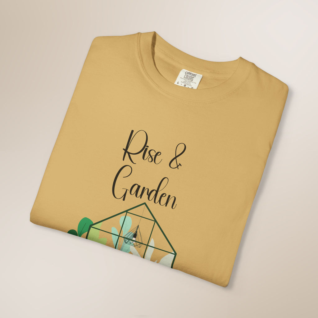 Folded mustard yellow t-shirt with 'Rise & Garden' text and green graphic on a beige background